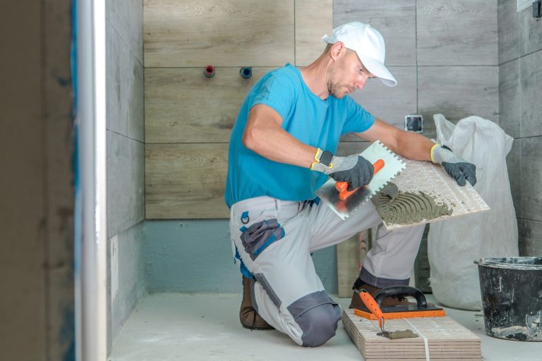 Remodeler setting tile in a bathroom